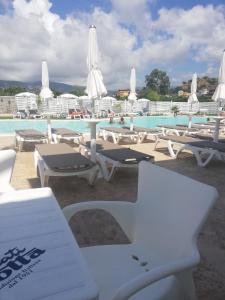 een groep tafels en stoelen naast een zwembad bij All'Ombra Del Noce B&B in Catona