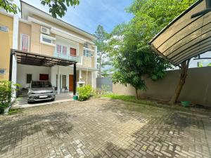 a house with a car parked in a driveway at Pesona Sinduadi Homestay Jogja in Jetis