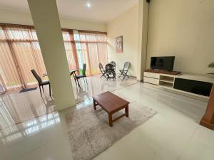 a living room with a tv and a table and chairs at Pesona Sinduadi Homestay Jogja in Jetis