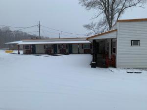 a house with a lot of snow in front of it at Tour Inn Motel in Howard City