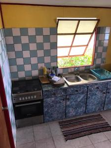 una cocina con fregadero y estufa en Fare OKAI, en Fitii