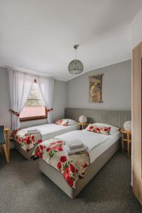 a bedroom with two beds and a window at Karczma Taberska in Kolesin