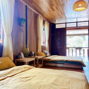 1 Schlafzimmer mit 2 Betten und einem Fenster in der Unterkunft May Garden Pleiku Homestay in Plei Hơlăng