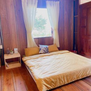 Bett in einem Zimmer mit Fenster in der Unterkunft May Garden Pleiku Homestay in Plei Hơlăng