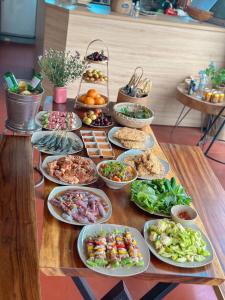 ein Tisch mit vielen Teller Essen drauf in der Unterkunft May Garden Pleiku Homestay in Plei Hơlăng