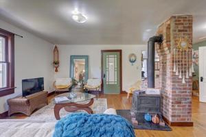 a living room with a brick fireplace and a table at Boho Garden Bungalow Near IU, Downtown, EV Level 2 Station in Bloomington