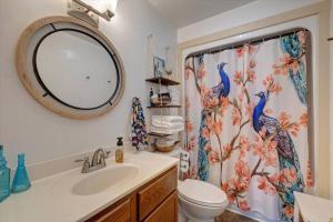a bathroom with a toilet and a shower curtain at Boho Garden Bungalow Near IU, Downtown, EV Level 2 Station in Bloomington +69 photos