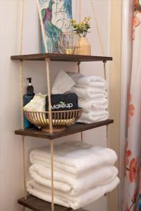 a wooden shelf with towels and a basket of towels at Boho Garden Bungalow Near IU, Downtown, EV Level 2 Station in Bloomington