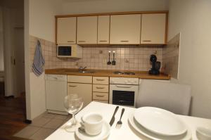 a kitchen with a table with plates and wine glasses at Schlafen in Stade in Stade