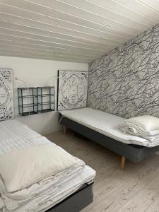 a bedroom with two beds and a wall with a mural at Villa Båthamnsgatan in Söråker