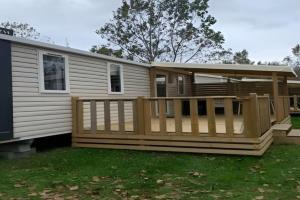 een stacaravan met een veranda en een terras bij Camping Riva Bella in Ouistreham