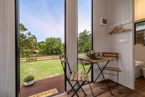 a tiny house with a balcony with a table and chairs at Brumby's Run 