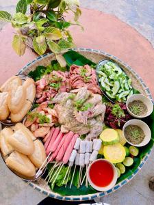 a plate of food with meat and vegetables on a table at WIND HILL HOMESTAY HÀ GIANG in Làng Me