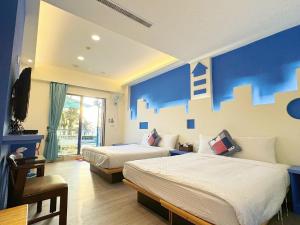 南灣的住宿－黃金海岸36海景旅店，酒店客房设有两张床和蓝色的墙壁。