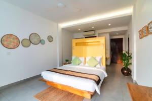 - une chambre avec un grand lit et une tête de lit jaune dans l'établissement Naiya Sea Resort, à Sihanoukville