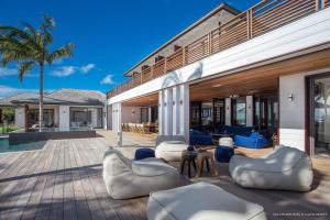 une terrasse d'une maison avec des chaises et un palmier dans l'établissement Luxury Vacation Villa 3, à Gustavia