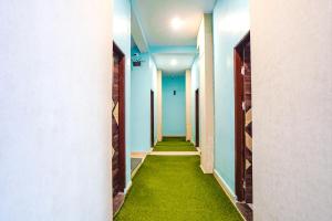 un pasillo con suelo verde en un edificio en FabExpress Evaan Deluxe Rooms, en Nagpur