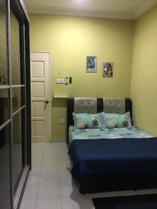 um quarto com uma cama com lençóis azuis e uma porta em BKB Homestay Bachok Kelantan em Bachok