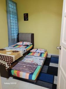 duas camas sentadas uma ao lado da outra num quarto em BKB Homestay Bachok Kelantan em Bachok