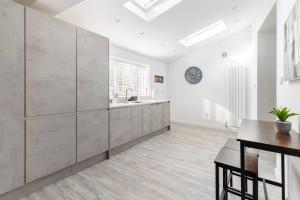 a kitchen with white walls and a sink and a table at Impressive 4 Bed House Sleeps 8 Private Parking, Fast WiFi 2x Smart TVs Netflix & Foosball, Business Travellers Relocaters Leisure Welcome in Haversham