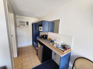 a small kitchen with blue cabinets and a counter top at Nanango Star Motel in Nanango