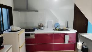 uma cozinha com um lavatório e um frigorífico vermelho e branco em シェアハウスの和室or洋室 24時間スーパー徒歩5分 共同ワークスペース有 em Gifu