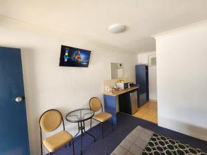 a room with a table and chairs and a kitchen at Nanango Star Motel in Nanango