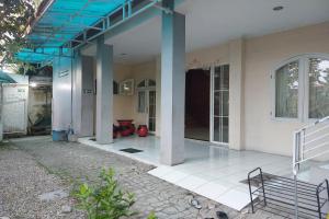 uma casa com um telhado azul e um alpendre em R Residence em Medan