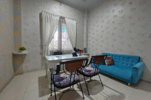 sala de estar con sofá azul, mesa y sillas en R Residence, en Medan