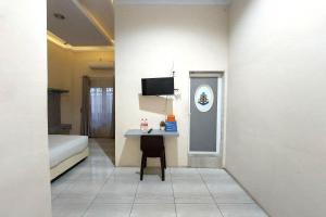 a room with a bed and a small table in it at R Residence in Medan