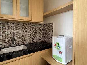 a small kitchen with a sink and a refrigerator at Urbanview Indria Inn Solo by RedDoorz in Bonorejo