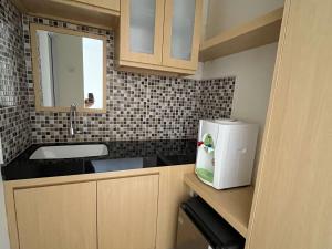 a small kitchen with a sink and a refrigerator at Urbanview Indria Inn Solo by RedDoorz in Bonorejo