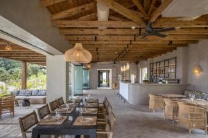 スパルティアにあるEliamos Villas Hotel & Spaの木製の天井、テーブルと椅子のあるレストラン