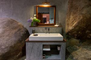 un bagno con lavandino e specchio di The Cavern ad Agrapatana