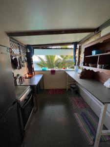 una pequeña cocina con encimera y nevera en Maui Homestay, en Tohautu