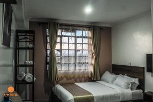 ein Schlafzimmer mit einem Bett und einem Fenster in der Unterkunft 5 PM Hotel in Nairobi
