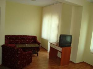 een woonkamer met een bank en een tv bij Хотелски Комплекс Авалон in Asenovgrad