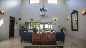 ein Wohnzimmer mit einem blauen Sofa und einem Tisch in der Unterkunft Ocean View Villa Full House Rate home in Cap Estate