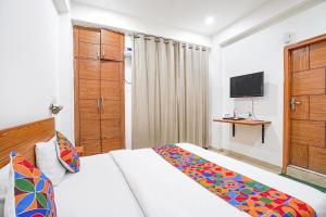 a hotel room with a bed and a television at FabHotel Prime Residency in New Delhi