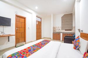 a bedroom with a large bed and a kitchen at FabHotel Prime Residency in New Delhi