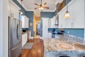 a large kitchen with white cabinets and a stainless steel refrigerator at Spacious Centrally Located Home in New Orleans
