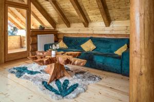 uma sala de estar com um sofá azul e uma mesa de madeira em Loghouse Madeira, Fužine. em Fužine