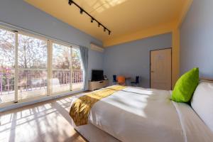a bedroom with a large bed and a large window at 光腳丫宜蘭民宿 in Dongshan