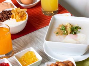 a table with a bowl of soup and bowls of food at Ibis Pattaya in Pattaya Central