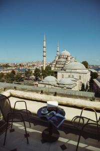 a table and chairs on a balcony with a view of a mosque at Mest Hotel Istanbul Sirkeci in Istanbul