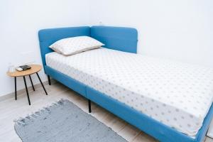 ein blaues Bett in einem Zimmer mit einem Tisch in der Unterkunft Serious Job Room in Dubrovnik