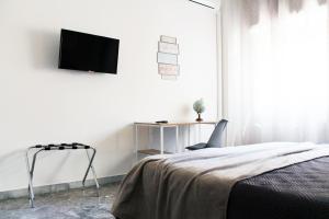 a bedroom with a bed and a tv on a wall at Stanze di Sofia in Bari