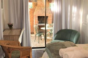 een woonkamer met een stoel en een open haard bij Woodlea self-catering flatlet in Pringle Bay