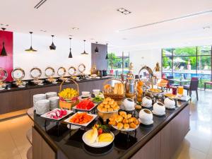 a buffet line with fruits and vegetables in a kitchen at Ibis Bangkok Riverside in Bangkok