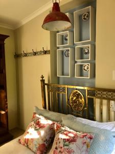 um quarto com uma cama e uma parede azul com placas em Houghton Rosebank Cottage with deck overlooking pool em Joanesburgo